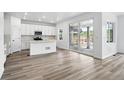 Modern kitchen with stainless steel appliances, white cabinets, and sliding glass doors to the backyard at 39713 Penn Rd, Elizabeth, CO 80107