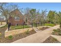 Beautiful brick home with manicured lawn, stone front wall, and wrought iron fence creating a welcoming entrance at 944 S Euclid Way, Denver, CO 80209
