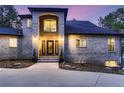 Brick home features a grand entrance with a double door and a welcoming front porch at 6517 Perry Park Blvd, Larkspur, CO 80118