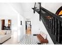Elegant entryway with patterned tile floor, black staircase, and bright lighting at 2844 N Humboldt St, Denver, CO 80205