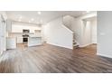 Open-concept living area with hardwood floors, a kitchen with stainless steel appliances, and a staircase at 19018 E 94Th Pl, Commerce City, CO 80022