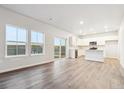 Bright living room featuring hardwood floors, large windows, and a sliding glass door to the outside at 19018 E 94Th Pl, Commerce City, CO 80022