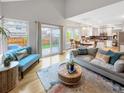 Open-concept living room with hardwood floors, bright windows, and access to backyard at 6002 Alkire Ct, Arvada, CO 80004