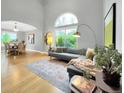 Bright living room showcasing vaulted ceilings, large windows, and an adjacent dining area at 6002 Alkire Ct, Arvada, CO 80004