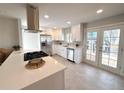 Bright kitchen featuring stainless appliances, white cabinetry, and a convenient center island with cooktop at 1853 S Filbert Ct, Denver, CO 80222