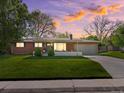 Charming brick ranch home with a well-manicured lawn and a long driveway leading to an attached garage at 3560 S Glencoe St, Denver, CO 80237