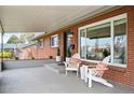 Cozy covered porch with seating, offering a welcoming entrance to this charming brick home at 3560 S Glencoe St, Denver, CO 80237