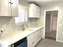 Bright kitchen with new white cabinets, marble countertop and backsplash, and stainless faucet at 1299 S Brentwood Way, Lakewood, CO 80232