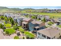 Wide aerial view showing a neighborhood of homes on a sunny day with a mountain backdrop at 18180 W 84Th Pl, Arvada, CO 80007
