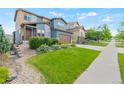 A lush green lawn and mature landscaping enhance the curb appeal of this charming home at 18180 W 84Th Pl, Arvada, CO 80007