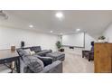 Finished basement with a large sectional sofa, projector screen, and neutral carpet at 1560 Hudson St, Denver, CO 80220