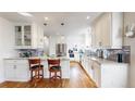 Contemporary kitchen featuring white cabinetry, stainless steel appliances, granite countertops, and hardwood floors at 1560 Hudson St, Denver, CO 80220