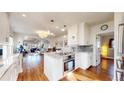 Bright kitchen with stainless steel appliances, white cabinets, and a center island open to the living area at 1560 Hudson St, Denver, CO 80220