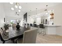 Open-concept living and dining area featuring modern lighting, fireplace, and breakfast bar at 6212 Kilmer Loop # 202, Golden, CO 80403