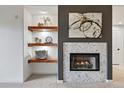 Modern living room detail: fireplace, floating shelves, and decorative art at 6212 Kilmer Loop # 202, Golden, CO 80403