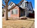 Inviting two-story home with blue siding, brick accents, a neatly maintained lawn, and a welcoming front entrance at 1022 Morning Dove Dr, Longmont, CO 80504