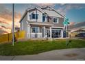 Inviting two-story home featuring a well-manicured lawn, stone accents, and a covered porch, creating a warm and welcoming facade at 716 N Carrie Ct, Watkins, CO 80137