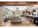 Spacious living area featuring exposed brick, wood floors, and large window for natural light at 4218 S Alton St, Greenwood Village, CO 80111