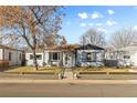 Inviting single-story home with a welcoming porch and beautifully landscaped front yard on a sunny day at 4389 S Sherman St, Englewood, CO 80113