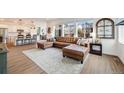 Bright, open-concept living room with large windows, hardwood floors and a comfortable leather sectional sofa at 14384 Big Stone Dr, Parker, CO 80134