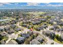 Expansive aerial view of a residential area with mountain views featuring a home with a three-car garage at 5289 W Euclid Pl, Littleton, CO 80123
