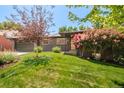 Quaint one-story home with colorful landscaping, an attached garage, and a well-maintained front lawn at 621 S Harrison Ln, Denver, CO 80209