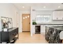 Bright modern kitchen features a marble waterfall island, white cabinets, and stainless steel appliances at 621 S Harrison Ln, Denver, CO 80209