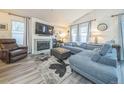 Cozy living room with fireplace, gray sofa, leather chair, and ample natural light at 12133 Crabapple St, Broomfield, CO 80020
