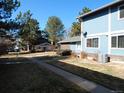Exterior view of the townhouse with mature trees and landscaping in a well-maintained community at 1255 S Wheeling Way, Aurora, CO 80012