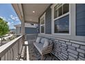 Inviting covered porch with stone accents and cozy seating area at 8049 Monte Vista Cir, Littleton, CO 80125