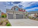 Charming exterior of a two-story home featuring stone accents and a spacious three-car garage at 21900 E 46Th Pl, Aurora, CO 80019