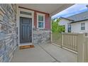 Inviting front porch with stone accents, a cozy mat, and view of the neighborhood at 21900 E 46Th Pl, Aurora, CO 80019