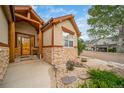 Close up view of the front of this home with a stone accent and a wood front door and frame at 2807 S Nelson St, Lakewood, CO 80227