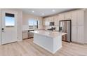 Bright open kitchen with stainless appliances, white cabinets, island, and a door to the outside at 24851 E 33Rd Dr, Aurora, CO 80019