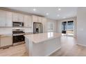 Bright kitchen featuring white cabinets, stainless steel appliances, and a large center island at 24851 E 33Rd Dr, Aurora, CO 80019