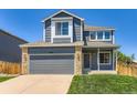Inviting two-story home featuring a gray exterior, attached garage, and well-manicured front lawn at 5663 W 118Th Pl, Westminster, CO 80020