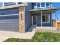 Home with gray exterior, gray garage door, and a covered front porch with white support columns at 5663 W 118Th Pl, Westminster, CO 80020