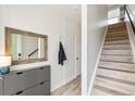 Hallway features light wood floors, hall tree, coat closet, modern dresser, and stairway to the upper level at 5375 W 14Th Ave, Lakewood, CO 80214