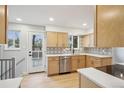 Modern kitchen featuring light wood cabinets, stainless steel appliances, and stylish backsplash at 9435 Osceola St, Westminster, CO 80031