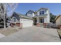 Charming two-story home showcasing a well-maintained lawn, mature tree, and attached two car garage at 2608 S Troy Ct, Aurora, CO 80014