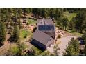 Aerial view shows a house with solar panels, complemented by a hot tub and outdoor hangout spot surrounded by towering trees at 1057 Reed Ranch Rd, Boulder, CO 80302