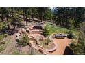 Inviting outdoor space features a hot tub, fire pit, and picnic table nestled amongst natural rock outcroppings and lush foliage at 1057 Reed Ranch Rd, Boulder, CO 80302