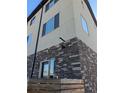 Multi-story exterior featuring stone accents, tan siding, and dark window frames under a sunny sky at 4737 E Iliff Ave, Denver, CO 80222