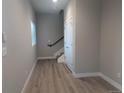 Neutral-toned hallway with staircase, featuring wood-look flooring and a window for natural light at 4737 E Iliff Ave, Denver, CO 80222