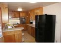 Functional kitchen with ample wood cabinetry and a breakfast bar, featuring a black refrigerator at 6363 County Road 20, Longmont, CO 80504
