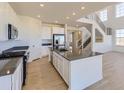 Open kitchen with large island, stainless appliances and hardwood-style floors at 39896 Floyd St, Elizabeth, CO 80107