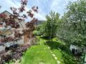 Large backyard with a grassy area, trees, and stone pathway at 3409-3415 W Moncrieff Pl, Denver, CO 80211