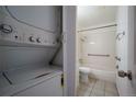 Well-lit bathroom with a shower-tub combo, tiled walls, and safety bars, conveniently located near the laundry at 8330 Zuni St # 214, Denver, CO 80221