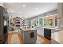 Open kitchen showcasing granite countertops, central island, modern appliances and sun-filled window at 7414 S Monroe Ct, Centennial, CO 80122