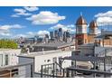 Rooftop view showcasing a cityscape, hot tub, and the neighborhood church buildings with a clear blue sky at 3615 Navajo St, Denver, CO 80211